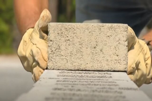 Worker building a block wall with gloves on